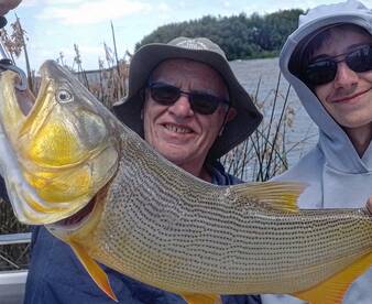Grandfather ando grandson sharing golden dorado