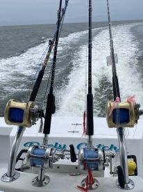 View of fishing rods and reels on the boat's console, showcasing the setup for an offshore fishing adventure.