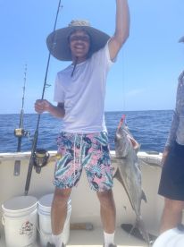 A young angler proudly displaying a large fish while fishing on a boat in open waters, showcasing a vibrant fishing environment.