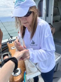 An angler carefully handling a fish on a charter boat, showcasing the excitement of fishing in open waters.