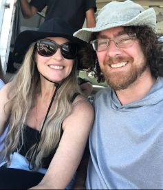 A smiling couple enjoying their time aboard a fishing charter, showcasing the comfortable seating area inside the boat.
