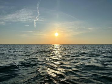 A serene sunset over the ocean, capturing the tranquil beauty of the water and sky.