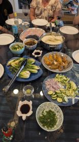 A dining table set with various dishes, including fish and vegetables, suggesting a meal preparation or gathering.