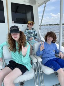 A group of young anglers enjoying their time on a fishing boat, showcasing a relaxed atmosphere with comfortable seating.