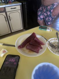 Freshly filleted tuna steaks displayed on a plate in a kitchen setting, highlighting the catch of the day.