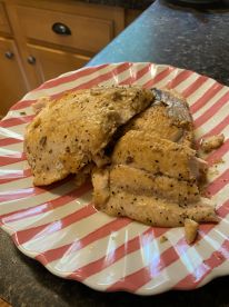 Cooked fish fillets presented on a striped plate, showcasing a delicious meal prepared from a recent fishing trip.