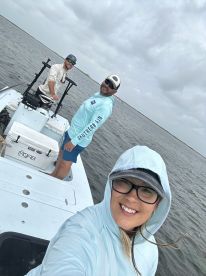 Three anglers enjoying a day on a fishing boat in calm waters, showcasing a relaxed atmosphere.