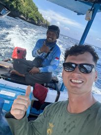Two anglers enjoying a fishing trip on a small boat, showcasing a scenic ocean backdrop and a relaxed atmosphere.