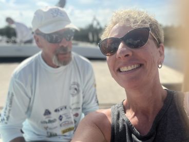 A selfie taken on a boat, featuring two individuals enjoying their time together, with a blurred background.