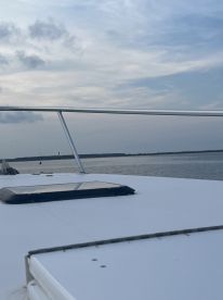 A scenic view of the boat's exterior with a calm water backdrop, showcasing the peaceful fishing environment.