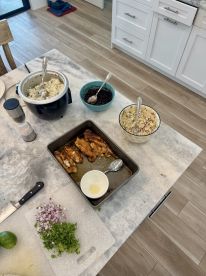 A kitchen scene featuring a variety of dishes, including cooked fish, rice, and salad, suggesting a meal preparation after a fishing trip.