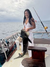A happy angler holding a large Mahi Mahi on a fishing charter, showcasing the excitement of deep-sea fishing.