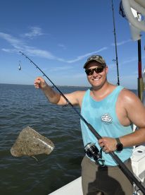 Angler proudly displaying a caught stingray while fishing on a sunny day, showcasing the excitement of saltwater fishing.