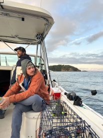 Two anglers relaxing inside a boat, enjoying the scenic view while preparing for their fishing adventure.