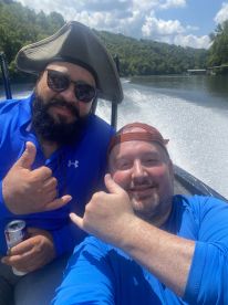 Two anglers enjoying a sunny day on the water, showcasing a fun moment during their fishing trip.