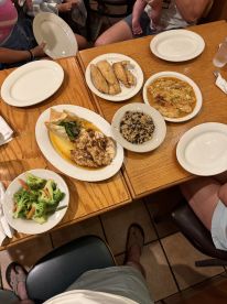 A dining table filled with various fish dishes and sides, showcasing a family meal experience.