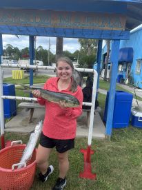 A young angler proudly displaying a large Mahi Mahi at Bayside Marina, showcasing a successful fishing trip.