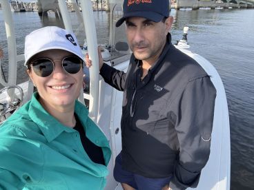 Two anglers enjoying a moment on the boat, showcasing the comfortable interior while preparing for a fishing adventure.