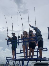 A group of anglers on a fishing platform, actively engaged in fishing with multiple rods, showcasing a lively fishing environment.