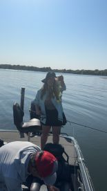 Angler proudly displaying a large bass while fishing on a sunny day, showcasing the excitement of a successful catch.
