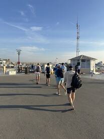 Group of anglers walking towards the marina, preparing for a fishing trip.