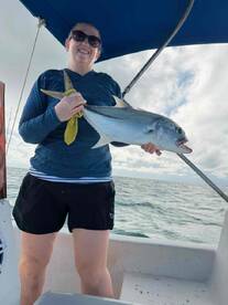 An angler proudly displaying a large fish while fishing on a boat, showcasing a successful day on the water.
