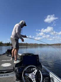 An angler casting a line while fishing on a calm lake, showcasing the excitement of the catch.