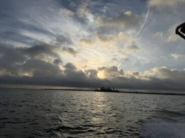 A scenic view of the water and clouds during a fishing trip, showcasing the tranquil atmosphere of the fishing environment.