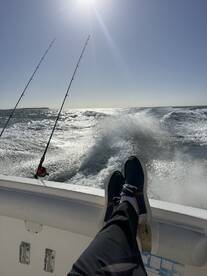 A relaxing moment on the boat with fishing rods in the background, capturing the essence of a day out on the water.