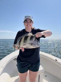 A young angler proudly displaying a Sheepshead fish while fishing on a sunny day.