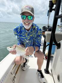 An angler proudly displaying a freshly caught fish while enjoying a day on the water.