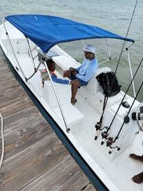 A father and son enjoying a moment together on a fishing boat, with fishing rods ready for their adventure.
