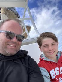 A father and son enjoying a moment together on the boat, showcasing the interior seating area.