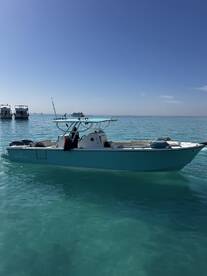 A sleek Bowfin boat anchored in clear turquoise waters, showcasing a beautiful day for fishing.