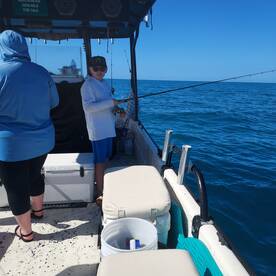 A young angler is actively fishing on a boat, showcasing the excitement of a day on the water.