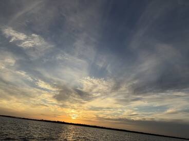 A scenic sunset over the water, capturing the tranquil beauty of the fishing environment.