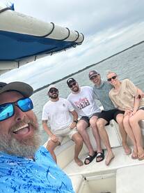 A cheerful group of friends enjoying a day on the boat, capturing a fun moment together on the water.