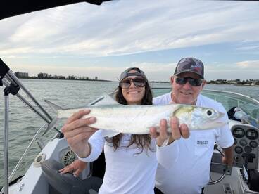 Two anglers proudly displaying a Silverfish while enjoying a day on the water, showcasing a fun family fishing experience.
