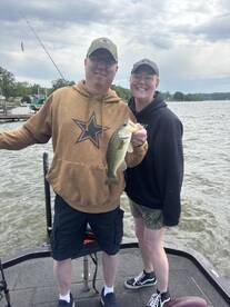 A proud moment for this duo as they display a large Largemouth Bass while fishing together on a scenic lake.