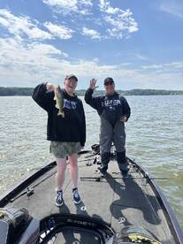 Two anglers enjoying a day on the water, with one proudly displaying a caught Largemouth Bass on a Ranger boat.