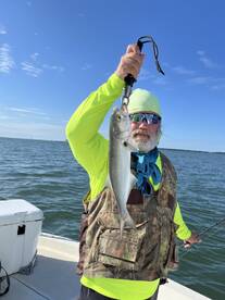 An angler proudly displaying a caught fish while fishing on a sunny day, showcasing the excitement of the catch.