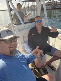 Three friends enjoying a day on a boat, showcasing a relaxed atmosphere with a view of the marina in the background.