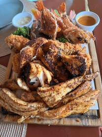A platter of assorted fried fish and seafood dishes, beautifully presented with dipping sauces.
