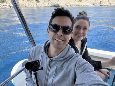 Two anglers enjoying a day on the water, capturing a selfie inside the boat with a scenic backdrop.