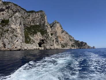 Scenic view of rugged cliffs along the coastline, captured from a boat, showcasing the beautiful marine environment.