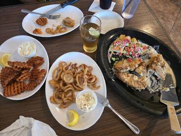 A table spread featuring various fried foods and a drink, likely enjoyed after a fishing trip.