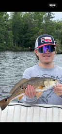 A young angler proudly displaying a freshly caught fish while enjoying a day on the water.