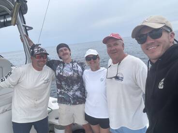 Group of anglers posing together on a boat, enjoying a day out on the water.