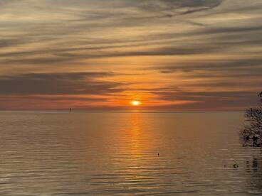 A serene sunset over calm waters, creating a picturesque fishing environment.
