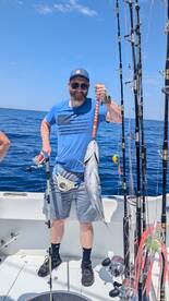 Angler proudly displaying a large fish while fishing offshore, showcasing a successful day on the water.